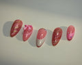 Set of pink and gold decorative nails on a white background